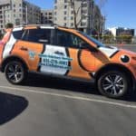 an orange and white car parked in a parking lot.