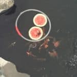 a plate of watermelon slices on a black surface.